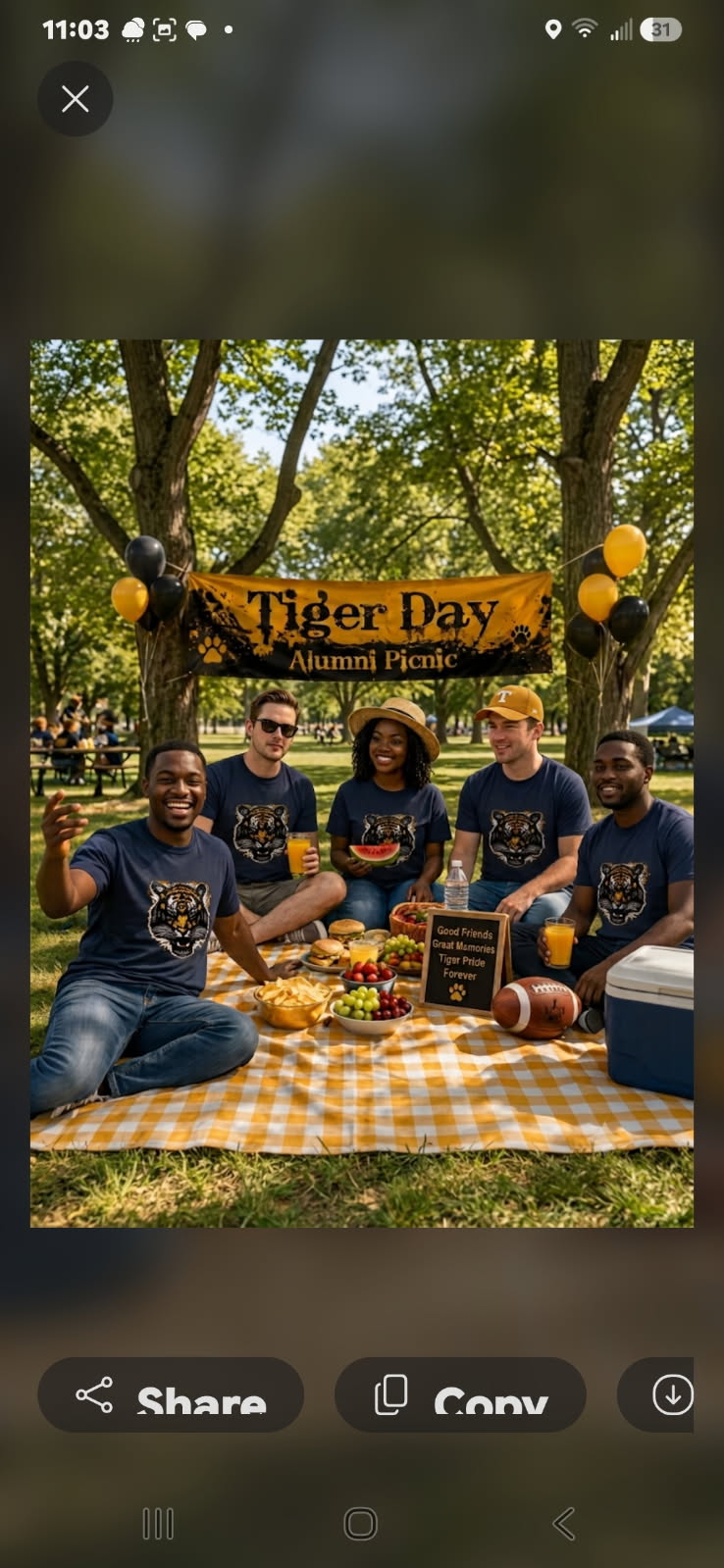 Alumni gathered on a checkered blanket in matching Tiger Day shirts beneath the picnic banner